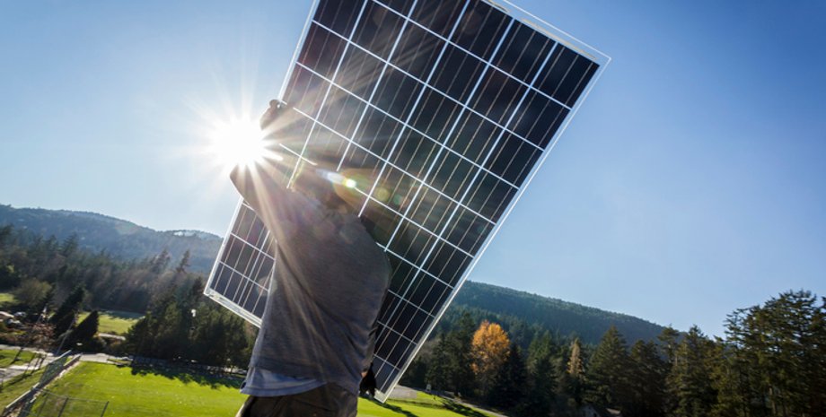 мужчина держит солнечную панель